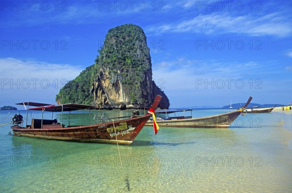 Rocks in the sea and longtail boats on Pranang Cave beach, two years in front of the tsunami,