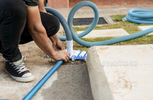Pool suction hose installation. Person connecting pool hose handle. Man connecting the handle on