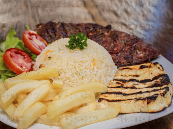 Close-up of roast beef with tomato salad and french fries, traditional barbecue roast beef food