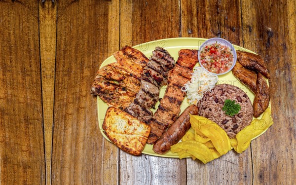 Varieties of grilled meats with rice, fried cheese and tomato salad, plate with assorted types of