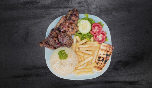 Plate of roasted chicken with rice and french fries on wooden table, Top view of plate of roasted