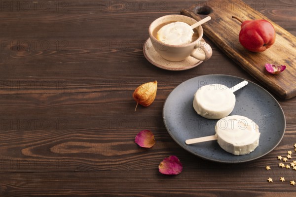 ?hocolate Ice cream in white glaze, cup of coffee, on brown wooden background, side view, copy