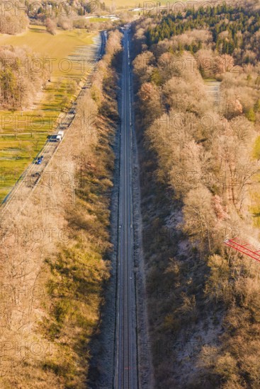 A railway line stretches through a dense forest landscape in winter, construction of the Hermann