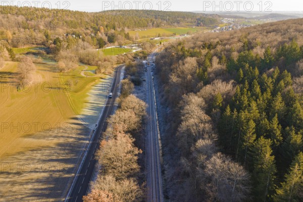 Aerial view of a railway line between trees and a road in a rural area, construction of the Hermann