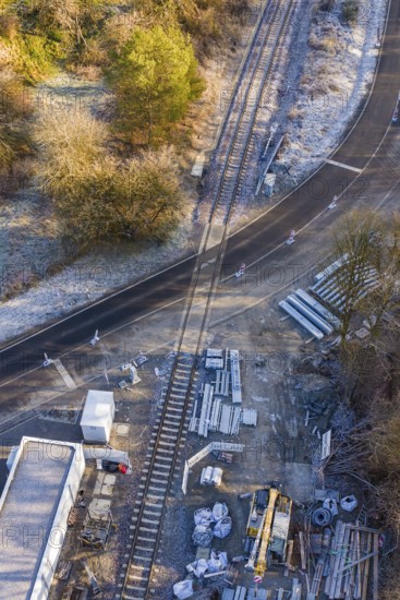 Construction site on a railway line with building materials next to a road, construction of the