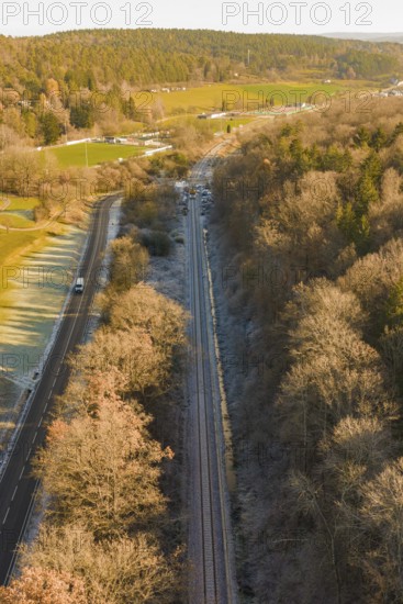 Railway line between trees and a country road in an autumn landscape, construction of the Hermann