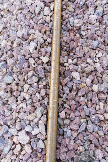 Close-up of gravel and a metal bar in a detailed view of the tracks, construction of the Hermann