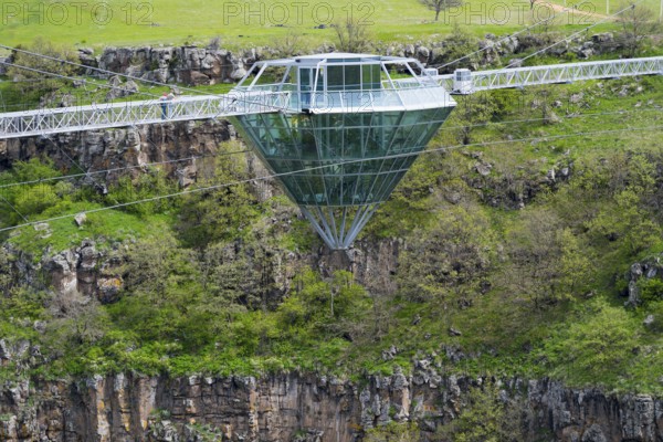 Modern glass bridge crosses green gorge with trees and rocks, diamond bridge, Diamond Glass Bridge,
