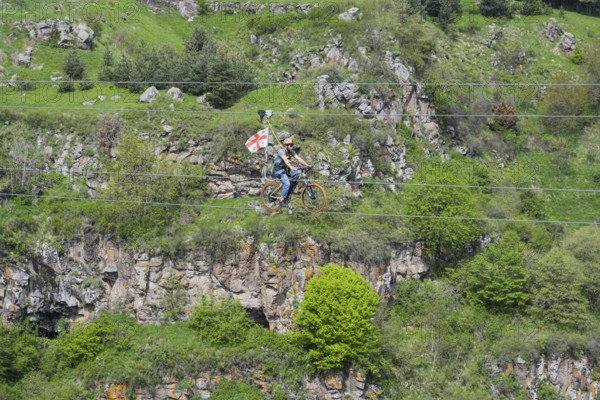 A bicycle ride on a rope leads across a rocky, green gorge, Dashbashi Gorge, Khrami River, Tsalka