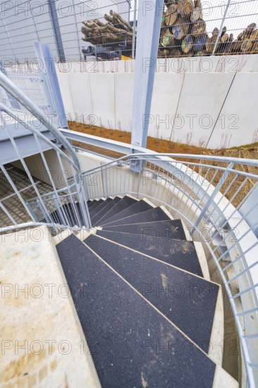 Downward spiral of steel and concrete staircase, showing modern building style, parking garage