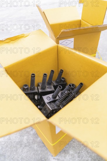 Open boxes with black charging stations inside, parking garage construction with charging