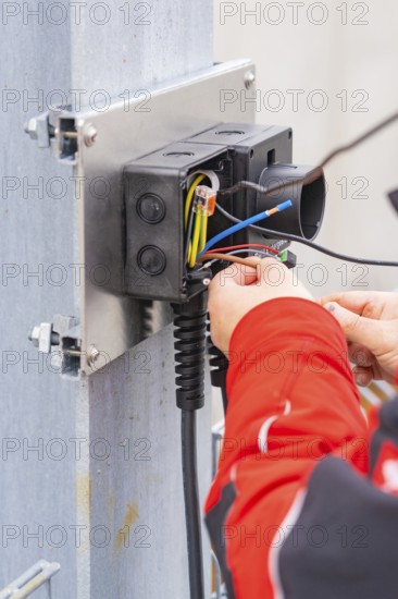 Detailed view of an electrician working on cables and connections, car park construction with