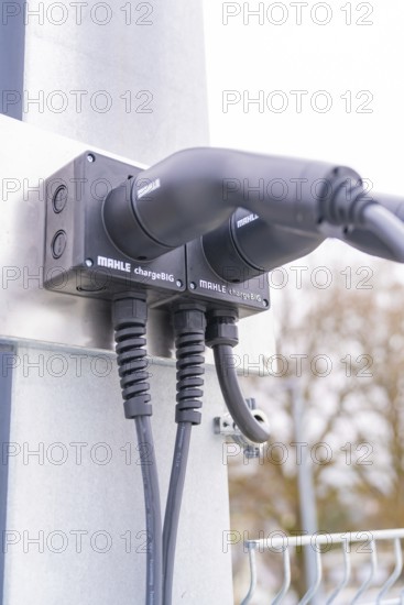 Modern electric charging station with cable connections on metal, parking garage construction with