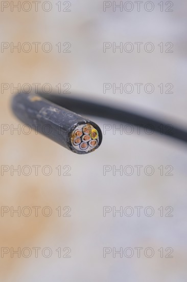 Sharp close-up of an electrical cable with multiple wires, parking garage construction with