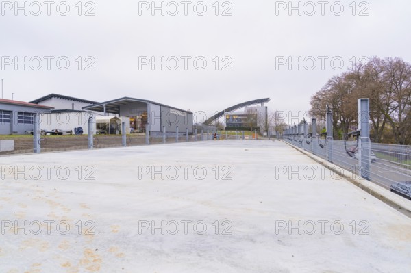 Industrial building in cloudy weather with an empty parking lot in the foreground, parking garage
