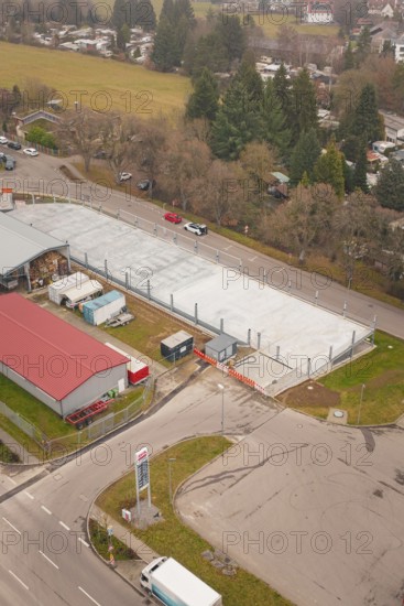 Urban aerial view with parking lot, roads and surrounding buildings, parking garage construction