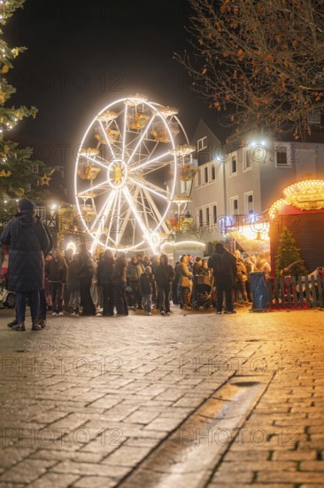 Illuminated Ferris wheel at a Christmas market with people in a festive mood, Weihnachtsmark