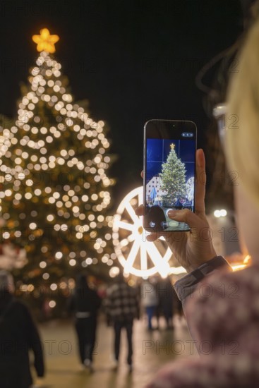 An illuminated tree at a Christmas market is captured with a smartphone, Weihnachtsmark Nagold,
