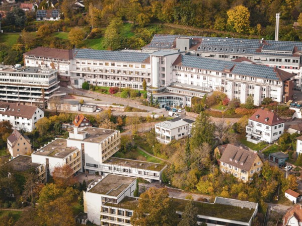 Close-up of buildings with solar panels and surrounding autumn trees in an urban landscape, Altes