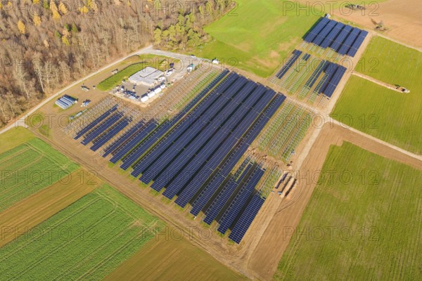 Extensive solar system surrounded by green fields, surrounded by autumn trees, energy revolution,