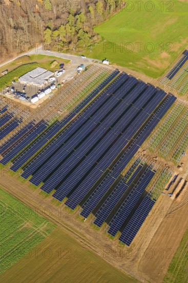 Aerial view of a large solar plant surrounded by autumn trees and fields, energy revolution,