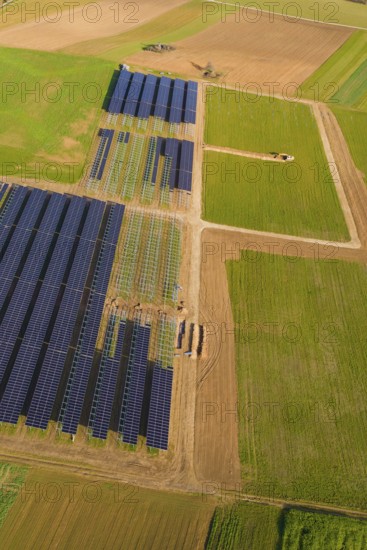 Bird's-eye view of solar panels on green fields in a rural area, Energiewende, construction of PV