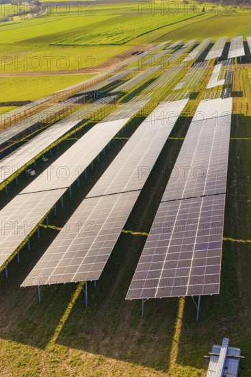 Close-up of solar cells on green fields under bright sky, Energiewende, construction of PV open