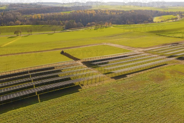Incomplete solar panel structures on a green area in a vast landscape, energy revolution,