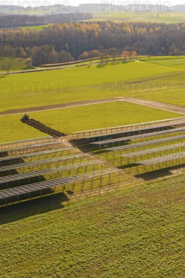 Incomplete solar park with empty structures and green land in autumn, energy revolution,