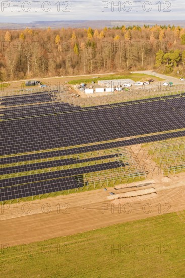 Large solar fields next to a forest area in autumn, energy revolution, construction of PV open