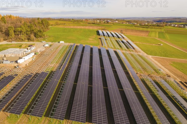 Large solar field surrounded by green fields and hills, sunny atmosphere, energy revolution,