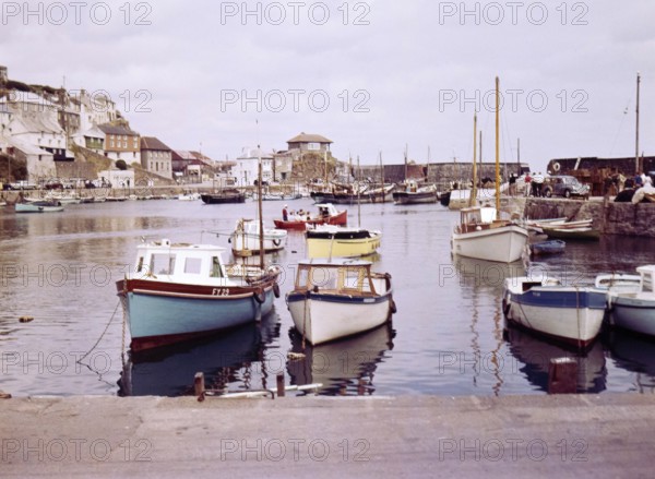 Boats at moorings in the harbour at seaside fishing village of Mevagissey, Cornwall, England, UK c