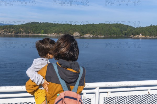 Mother and child enjoying the scenic ocean view from a ferry deck on the journey from victoria to