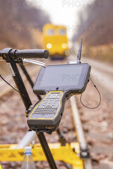 A technical device with a screen on a rail surveyor in the blur of the background, stuffing machine