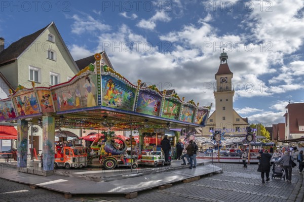 Children's carousel at the town festival on the market square, in the back the town hall, building