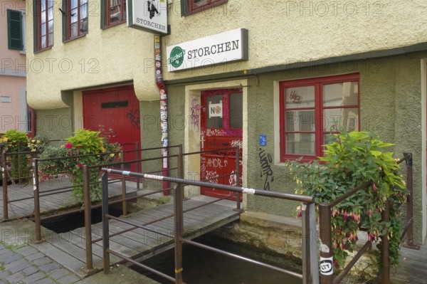Pub, stork, traditional restaurant, beer pub on the river Ammer, red front door, graffiti, bridge,