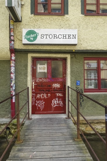 Pub, stork, traditional restaurant, beer pub on the river Ammer, red front door, graffiti, bridge,