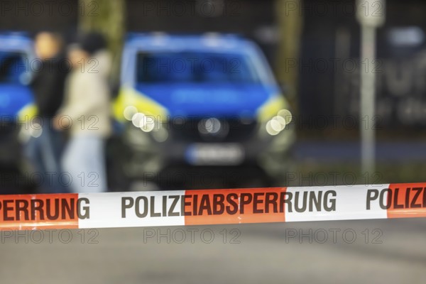 Flutter tape with the inscription police barrier. Behind it, a police car. Stuttgart,