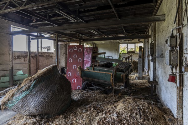 Old building with straw and equipment, dilapidated plant of a former agricultural production