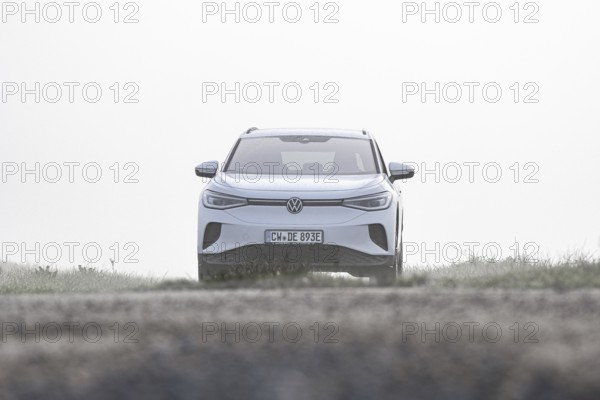 A white car from the front in a foggy, open environment, VW ID4 electric car, Deer Carsharing,