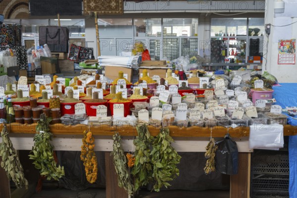 An extensive market stand with spices in red buckets and dried herbs, Akhaltsikhe market,
