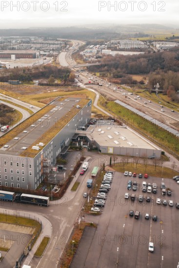 View from above of an industrial area with parking spaces next to a busy motorway, Böblingen,