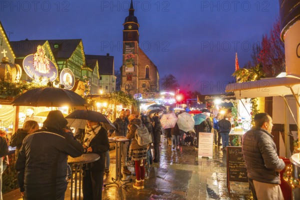 People with umbrellas and festive lighting at a Christmas market at night, Böblingen Christmas