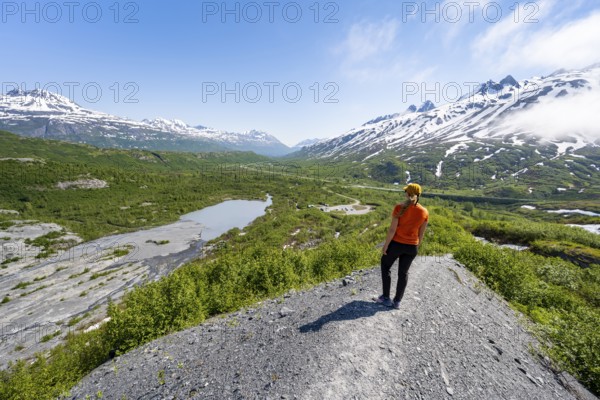 Female hiker on glacial moraine, view of the vast Tsina River valley with mountains, Worthington