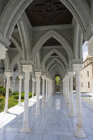 Impressive marble in an arcade under a blue sky with carved details on the pillars, Rabati