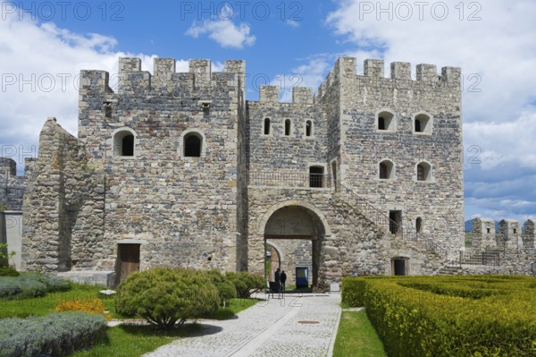 Massive stone fortress with towers and well-kept garden under slightly cloudy sky, Rabati fortress,