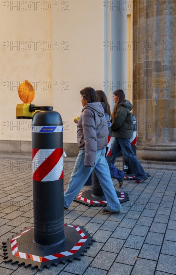 Passers-by at the security barrier made of massive bollards at the Brandenburg Gate passage,