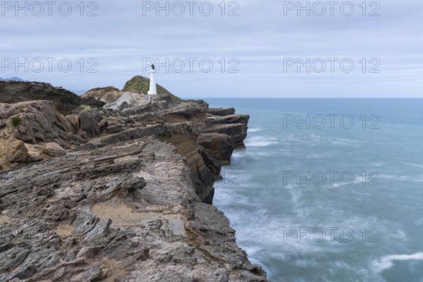 Castlepoint lighthouse on a rock, sea, long exposure. Castlepoint, Wairarapa Coast, Wellington