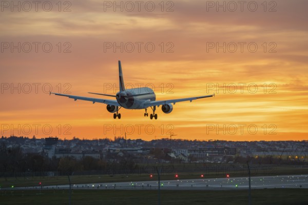 Airplane flying over illuminated runway at sunset, Stuttgart Airport, Leinfelden-Echterdingen,