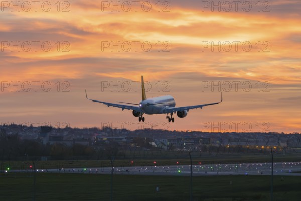 Airplane approaching urban landscape at bright sunset, Stuttgart Airport, Leinfelden-Echterdingen,
